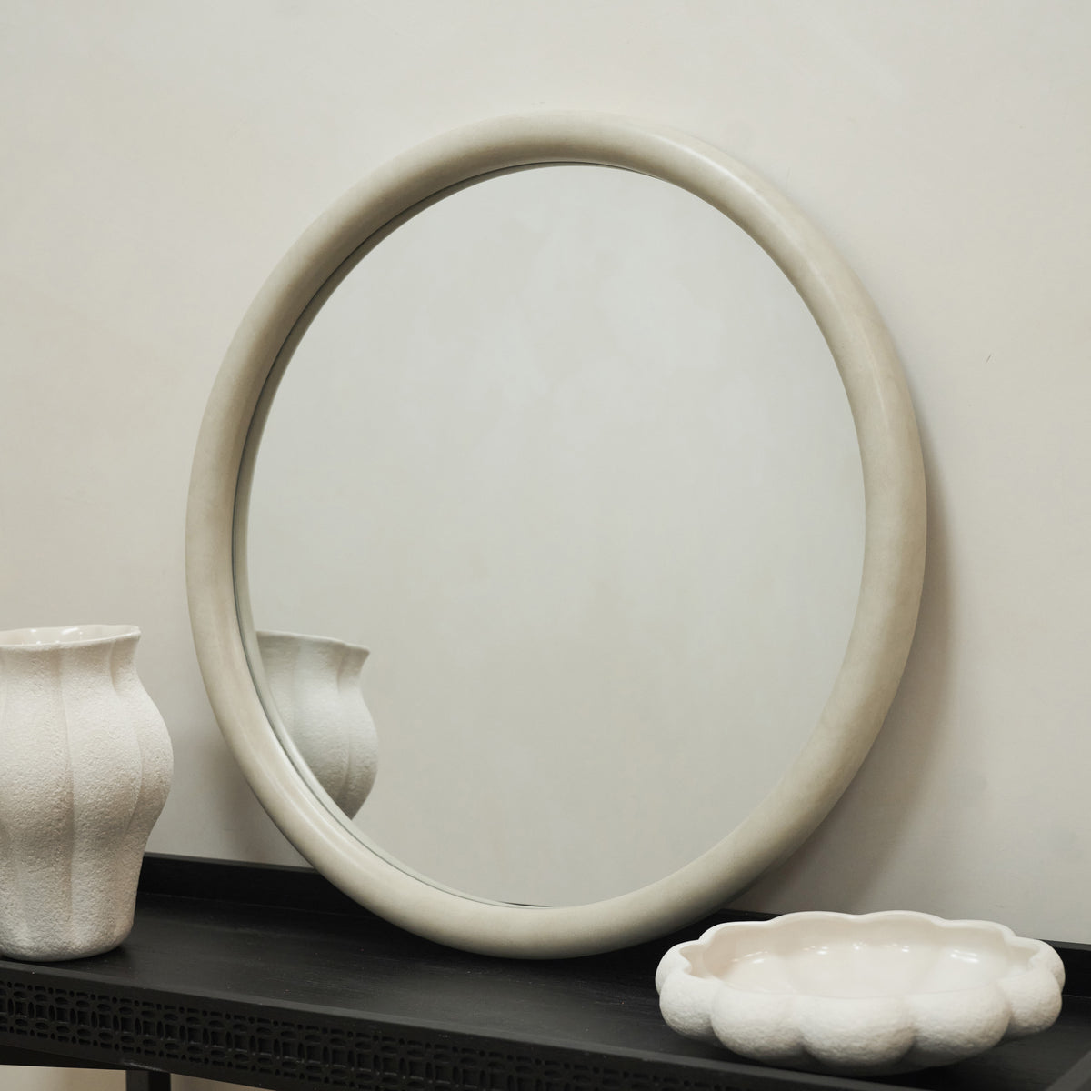 Our Concrete Round Wall Mirror leaning against a wall