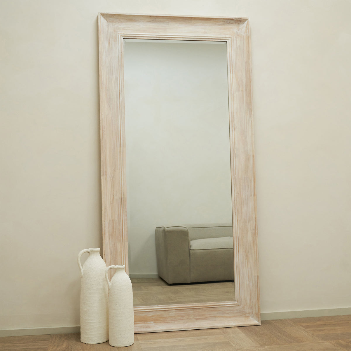 White washed wood full length mirror leaning against wall