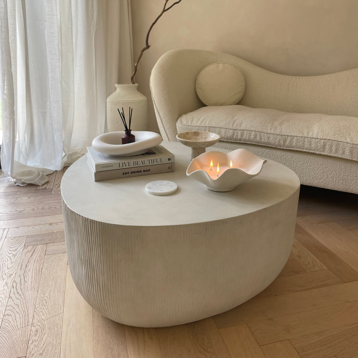Minimal Concrete Irregular Shaped Coffee Table Large in a typical setting, candles lit