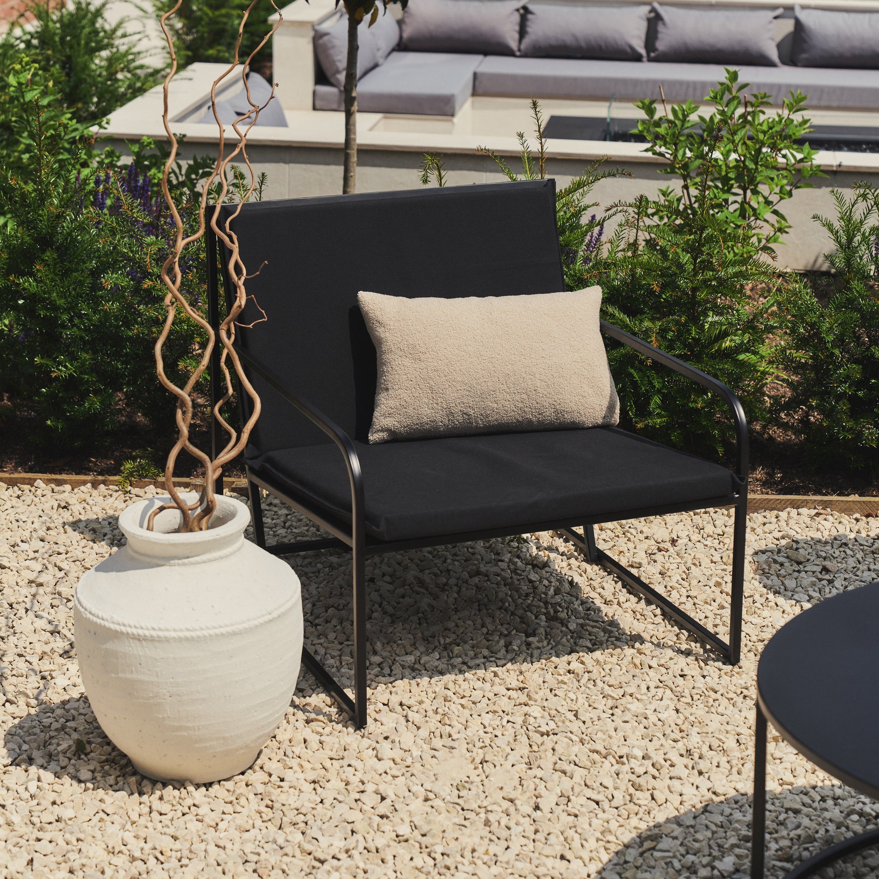 Rounded Black Modern Garden Chair beside white vase