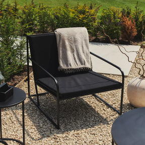 Rounded Black Modern Garden Chair beside concrete path