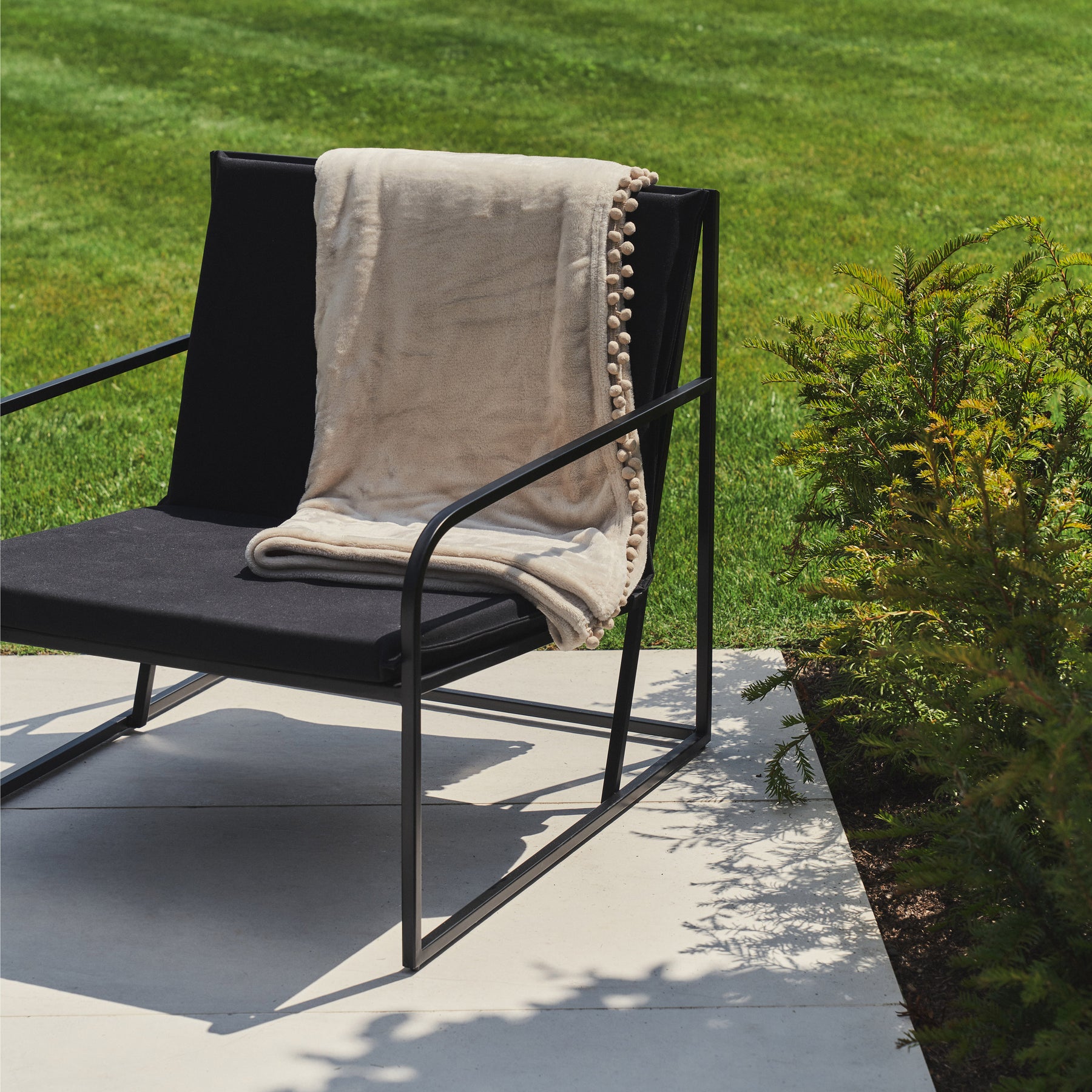 Rounded Black Modern Garden Chair beside plants