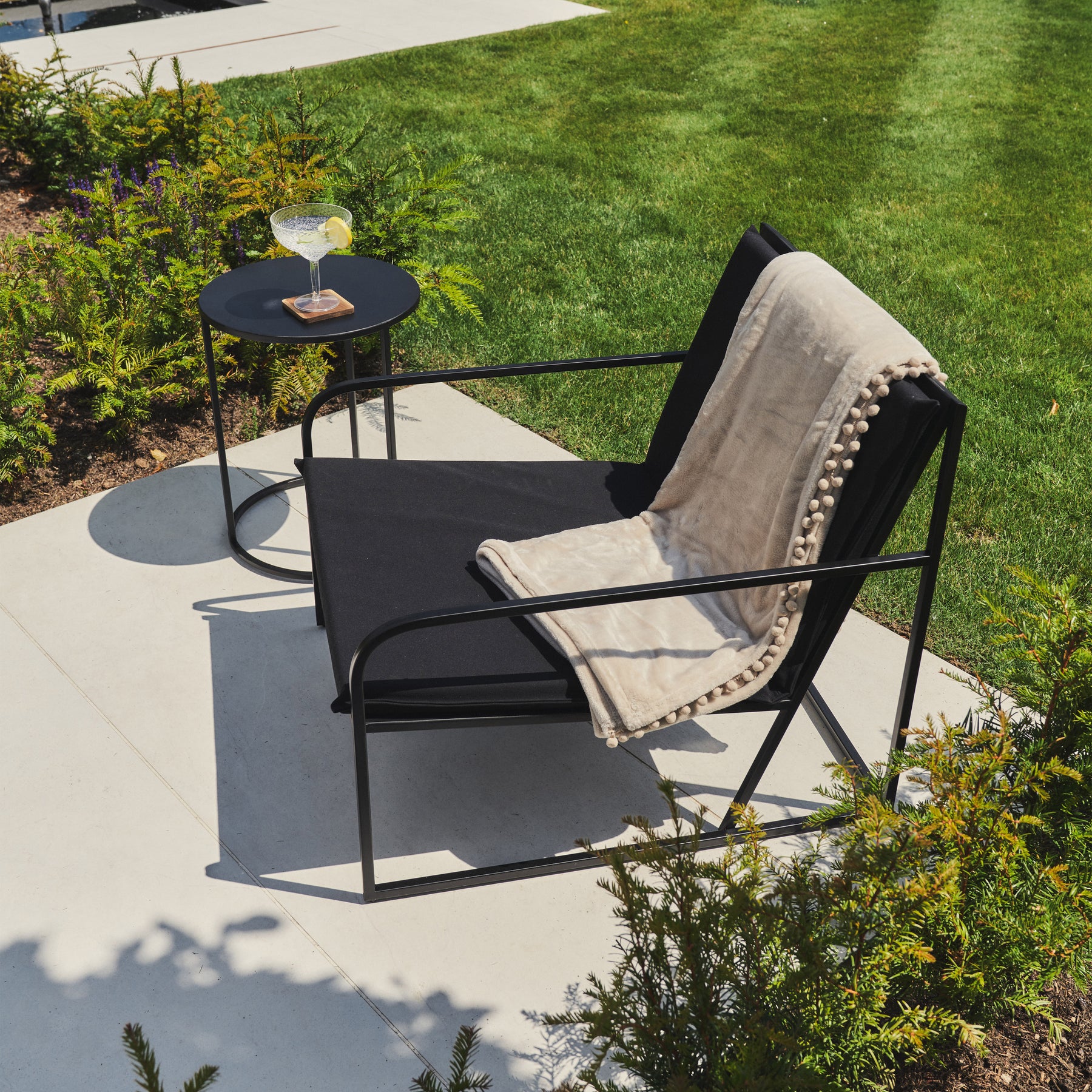 Rounded Black Modern Garden Chair beside side table