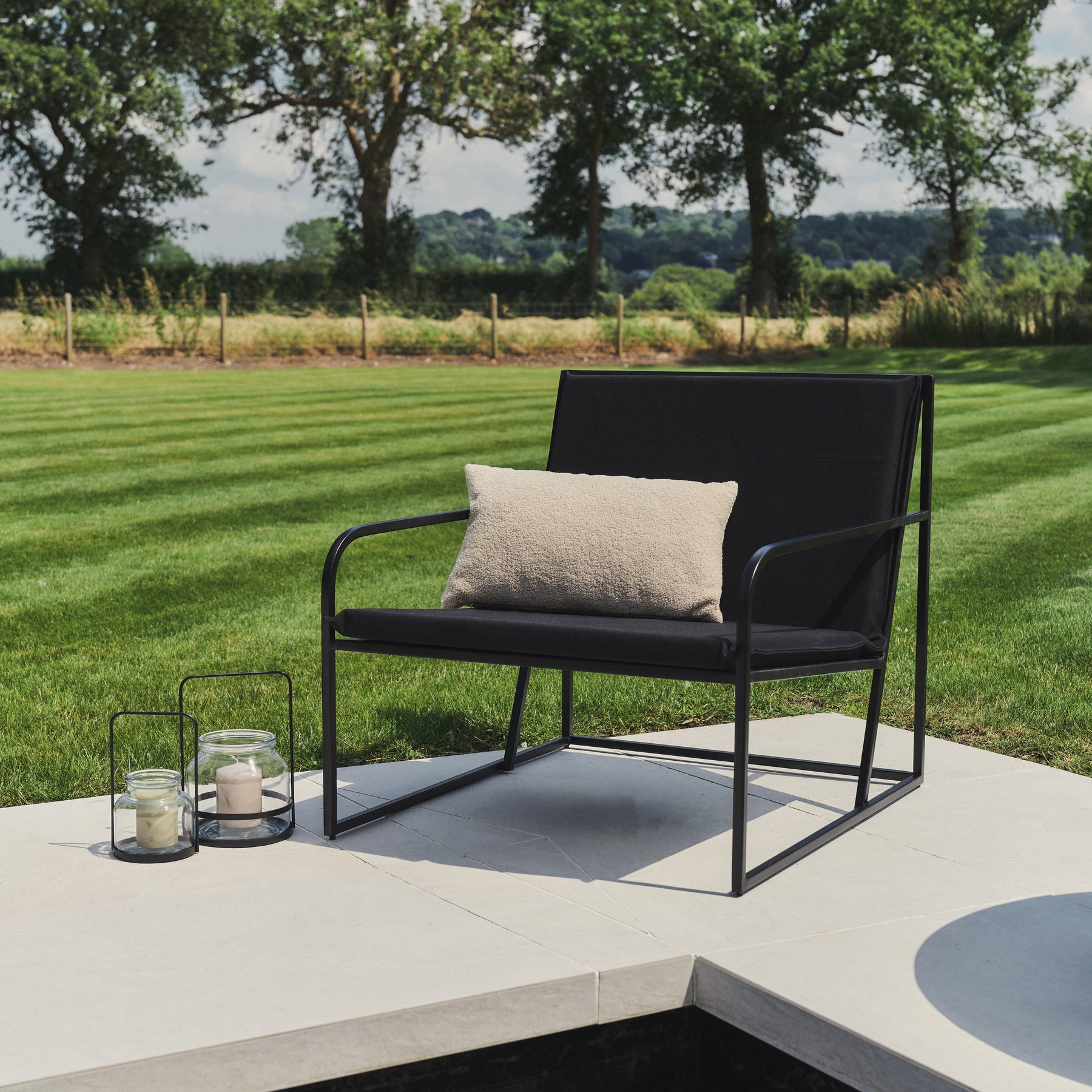 Black Modern Rounded Garden Chair adorned with cushion