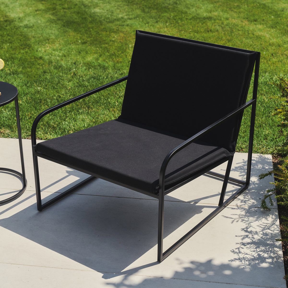 Rounded Black Modern Garden Chair in a typical setting