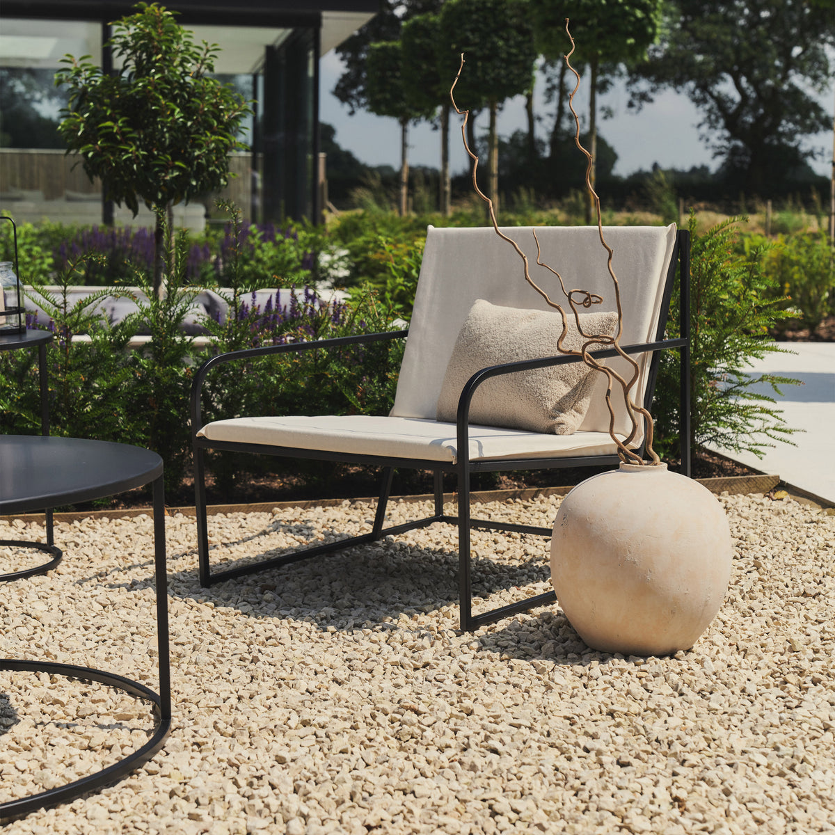 Sand Modern Rounded Garden Chair beside vase