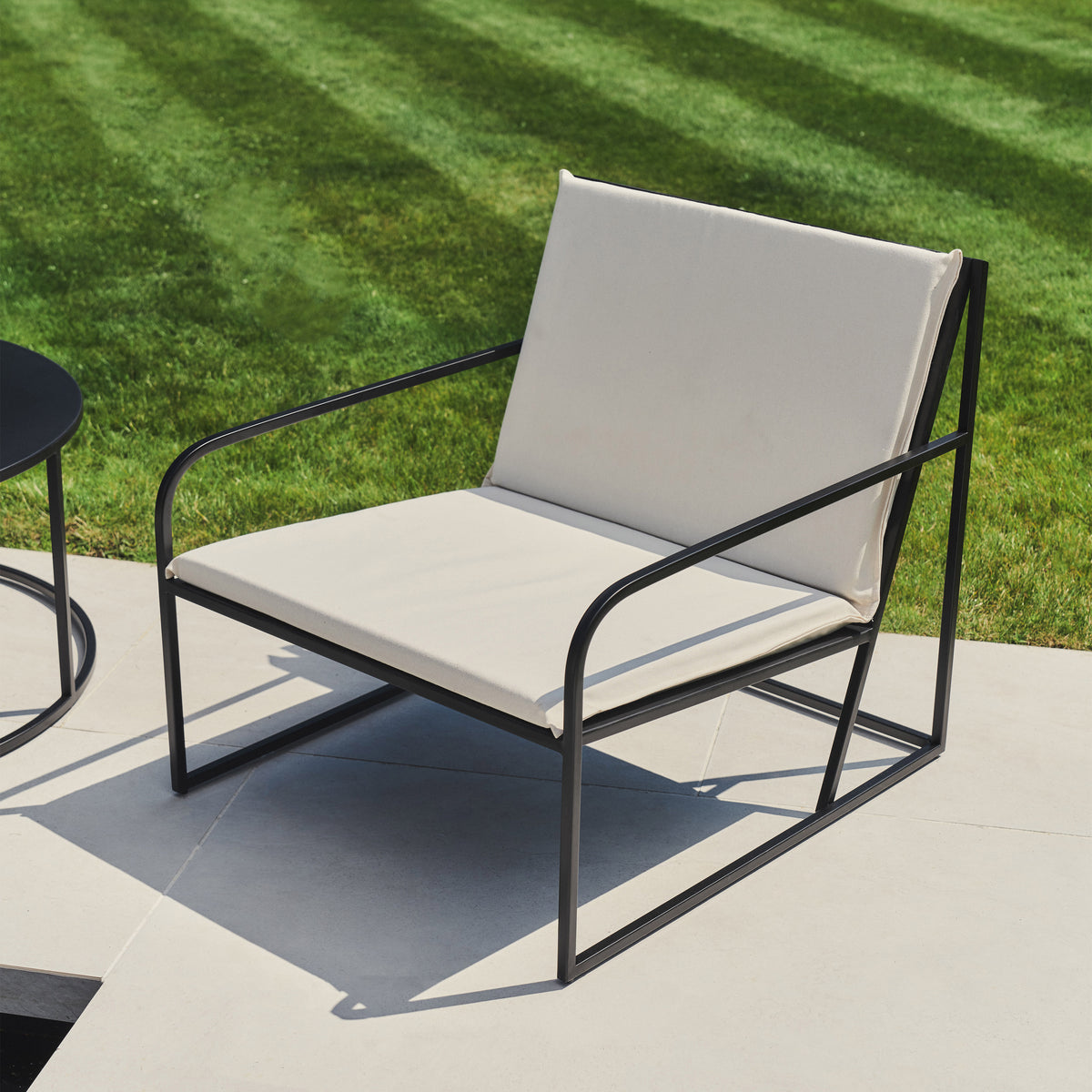 Sand Modern Rounded Garden Chair on concrete tiles