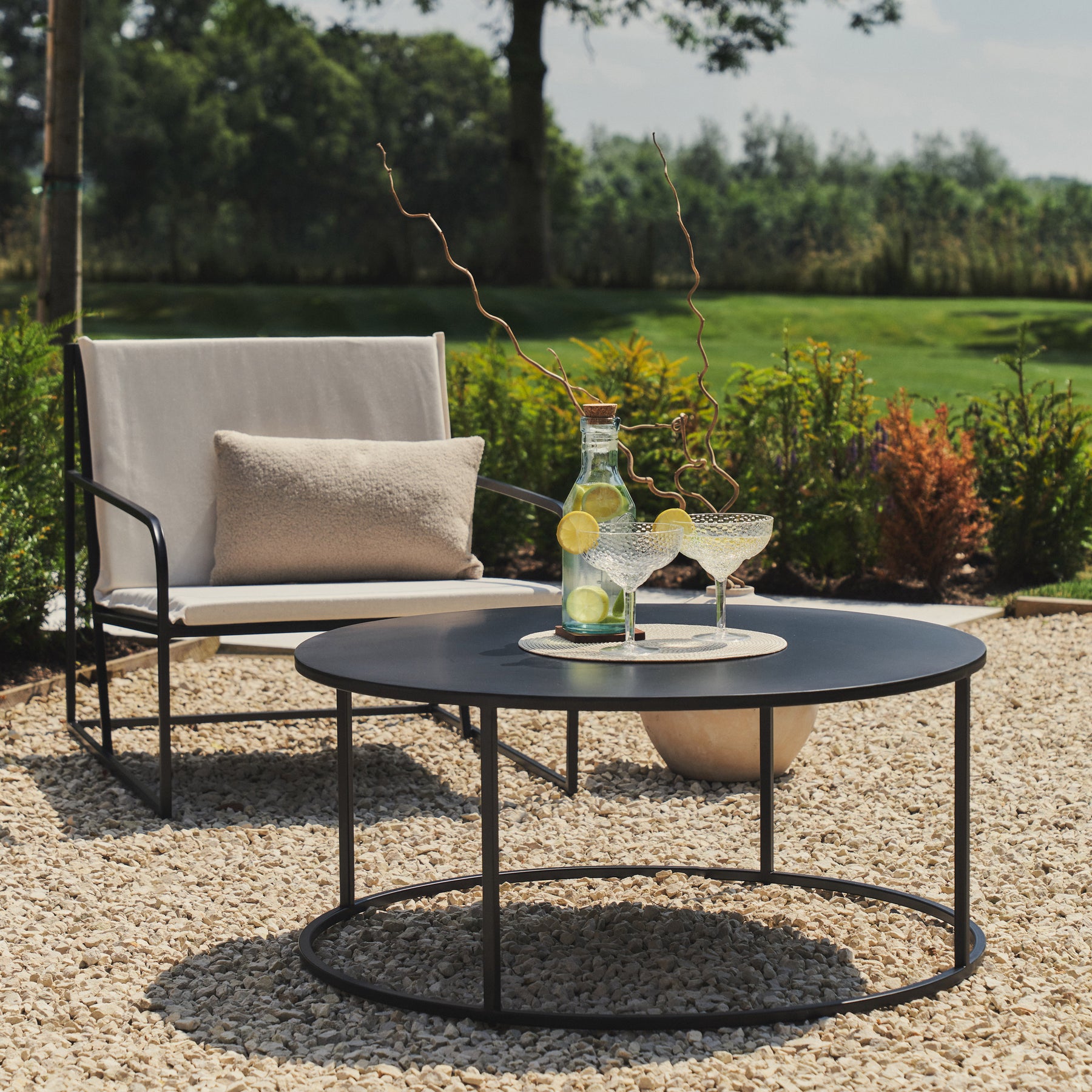 Select pieces of our Sand Modern Rounded Garden Furniture Set with a citrus drink