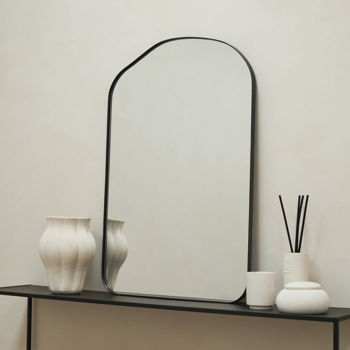 Irregular Arched Black Metal Wall Mirror on console table