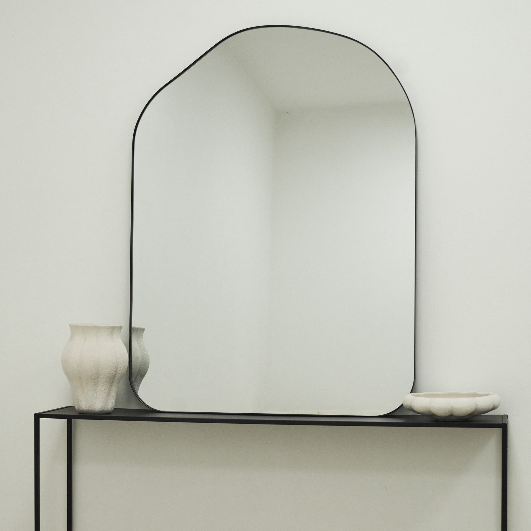 Large Irregular Arched Black Metal Wall Mirror on console table